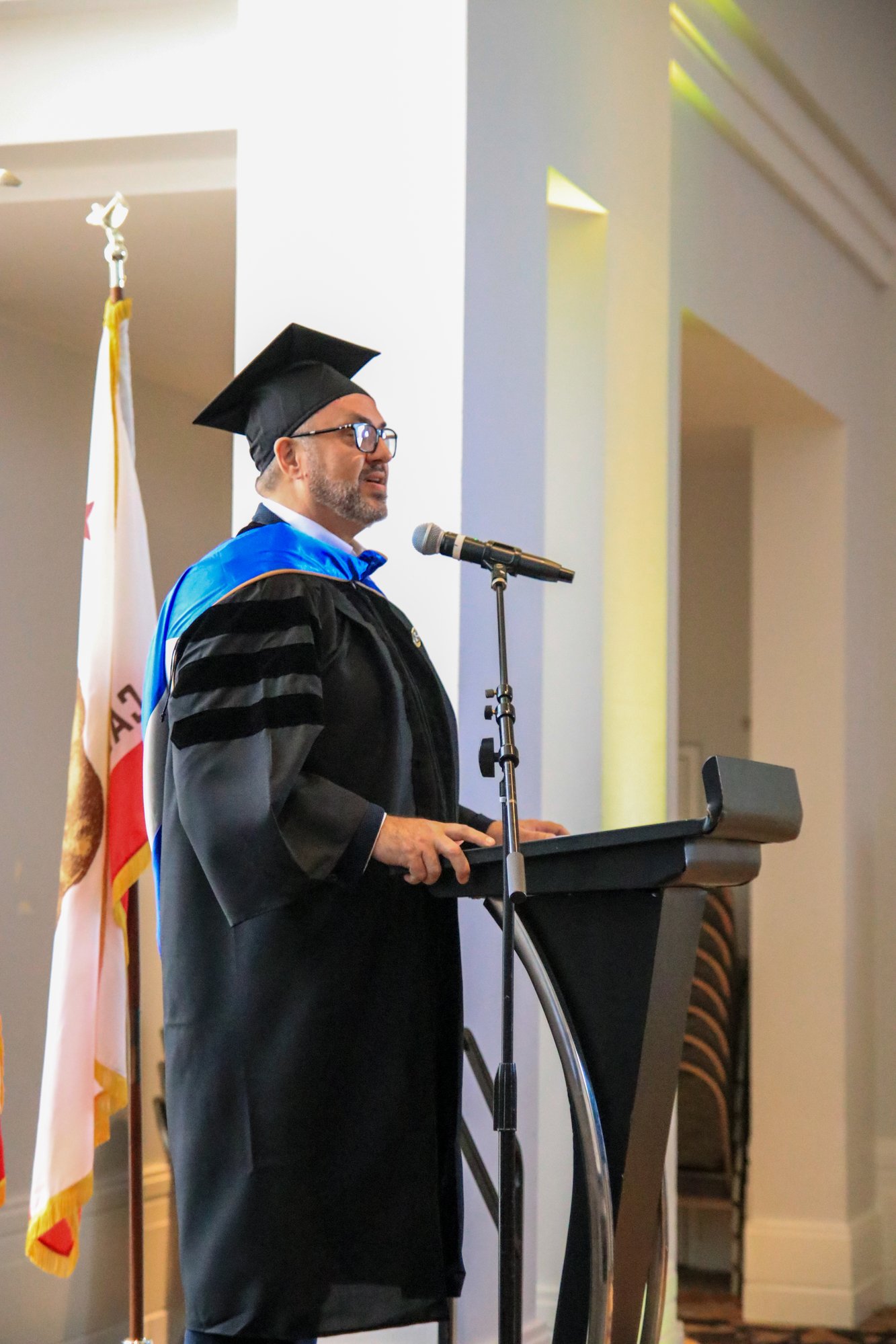 CalMU COO delivering address at commencement podium