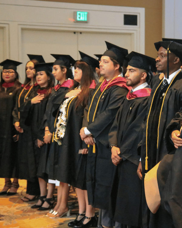 CalMU graduates standing during commencement ceremony