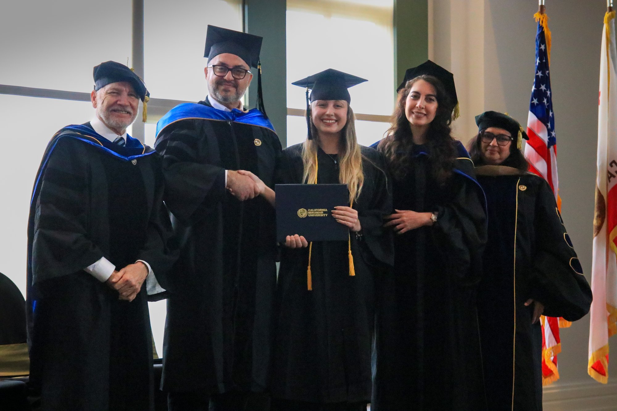 CalMU graduates at commencement with American flag